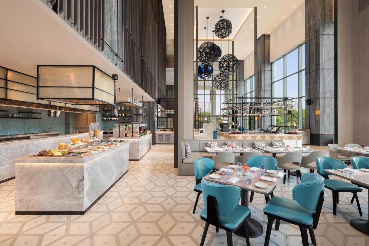 a rendering of a restaurant with tables and chairs at Le Meridien Ahmedabad in Ahmedabad