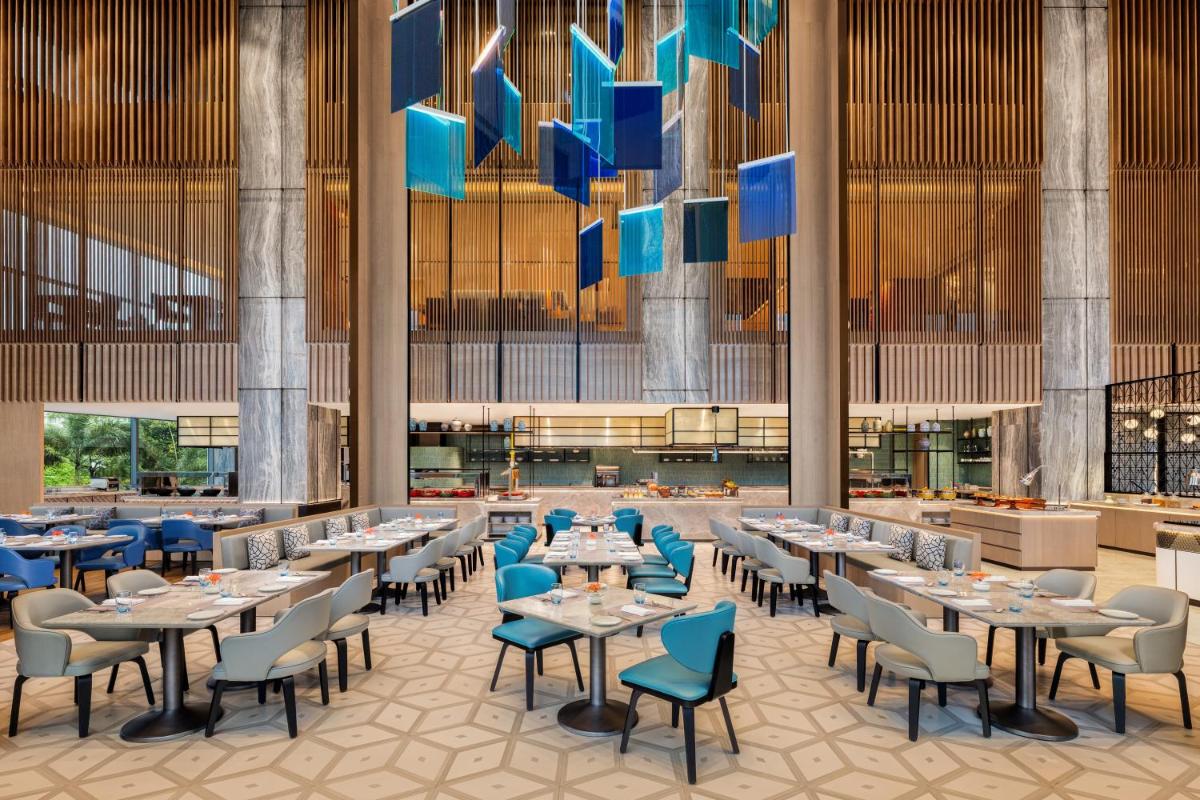 a rendering of a restaurant with tables and chairs at Le Meridien Ahmedabad in Ahmedabad