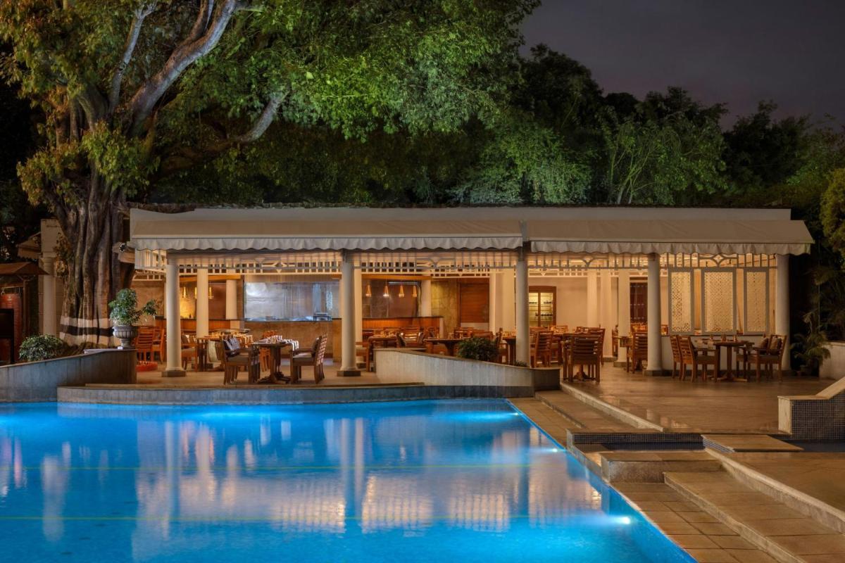 a swimming pool in front of a restaurant at night at ITC Windsor, a Luxury Collection Hotel, Bengaluru in Bengaluru a swimming pool in front of a restaurant at night at ITC Windsor, a Luxury Collection Hotel, Bengaluru in Bengaluru