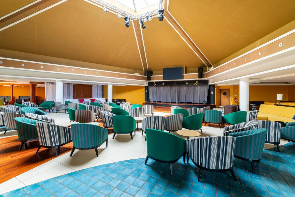 um quarto amplo com cadeiras e mesas verdes em Pestana Porto Santo Premium All Inclusive Beach & SPA Resort em Porto Santo mais 46 fotografias