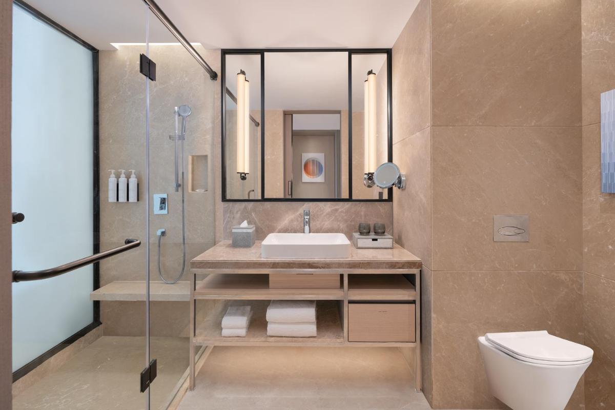 a bathroom with a sink and a shower and a toilet at Le Meridien Ahmedabad in Ahmedabad