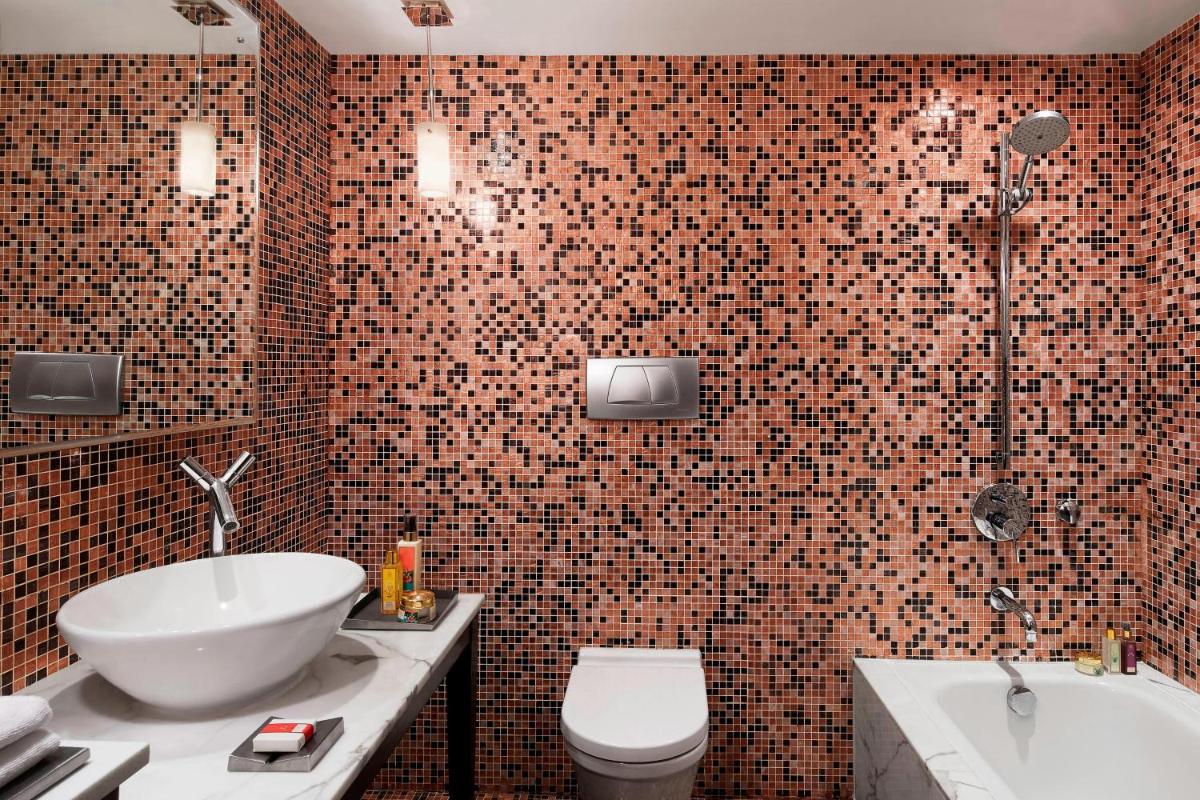 a bathroom with a sink and a toilet and a tub at Le Meridien New Delhi in New Delhi a bathroom with a sink and a toilet and a tub at Le Meridien New Delhi in New Delhi