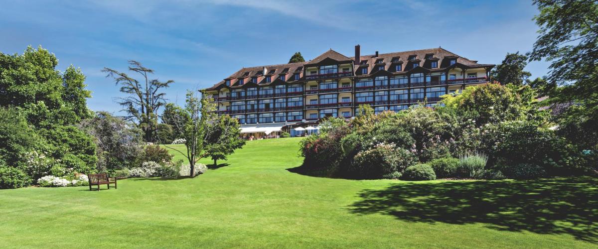 - un grand bâtiment au-dessus d'un champ verdoyant dans l'établissement Hôtel Ermitage, à Évian-les-Bains