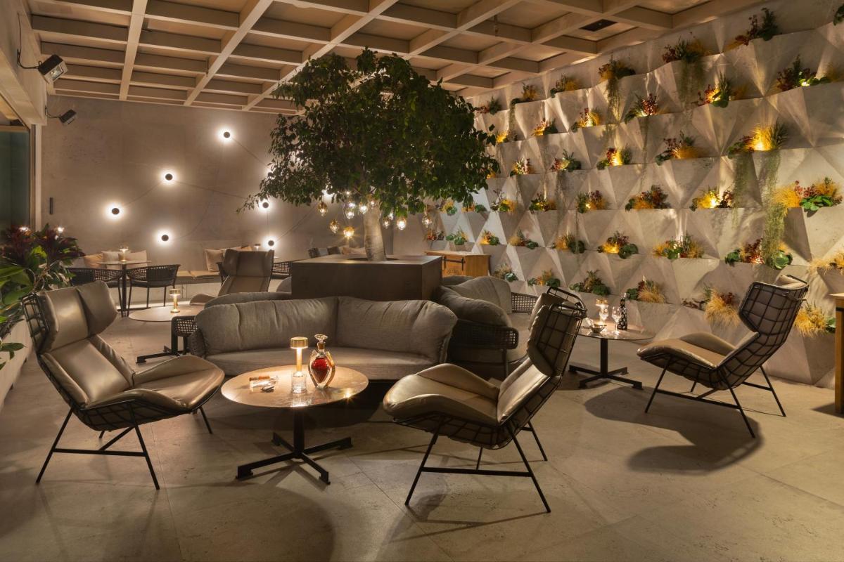 uma sala de estar com sofá, cadeiras e uma mesa em EPIC SANA Marquês Hotel em Lisboa