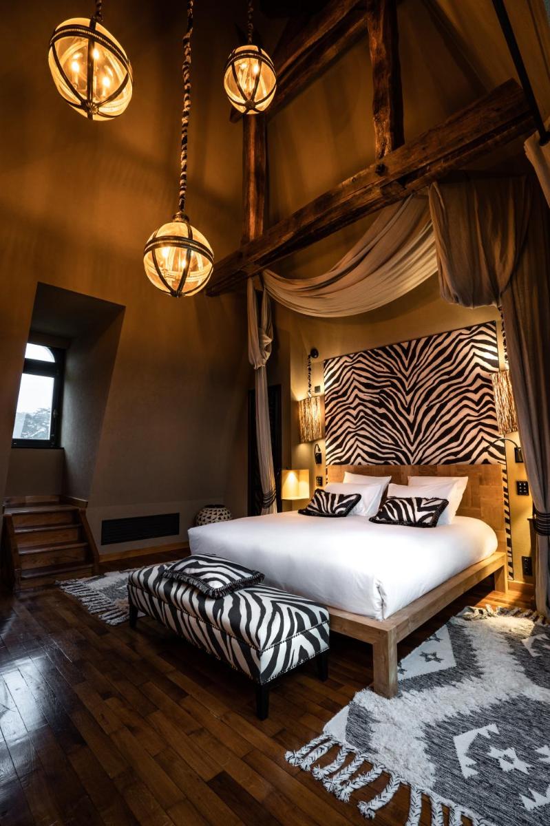 - une chambre avec un lit à baldaquin et des oreillers zébrés dans l'établissement Château de Maubreuil, à Carquefou