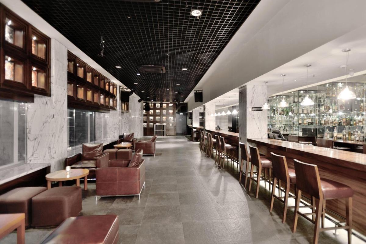 a restaurant with chairs and tables and a bar at Marriott Suites Pune in Pune