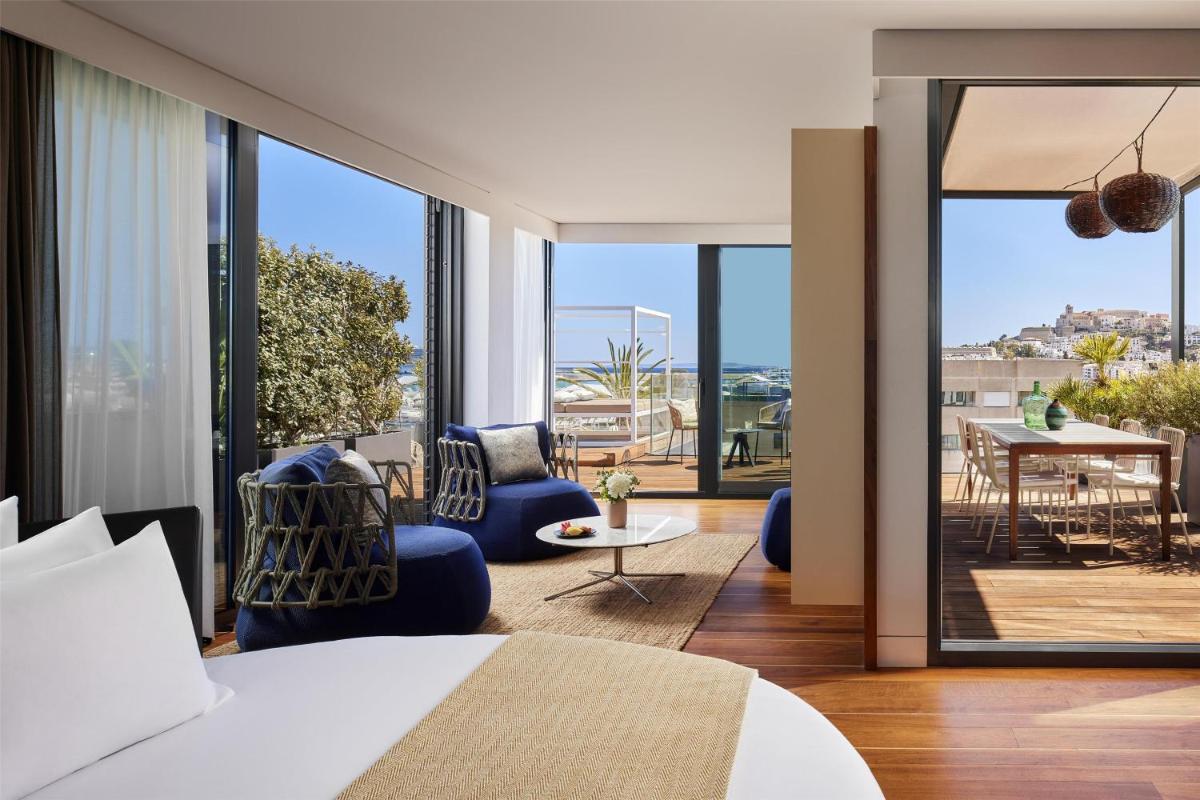Un dormitorio con una cama y vista a un patio. en NH Collection Ibiza, en Ibiza