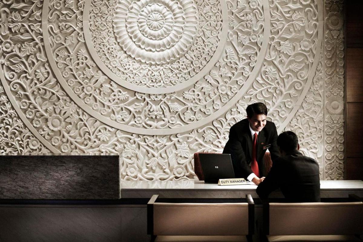 two men sitting at a table with a laptop at Crowne Plaza Today Gurugram by IHG in Gurgaon