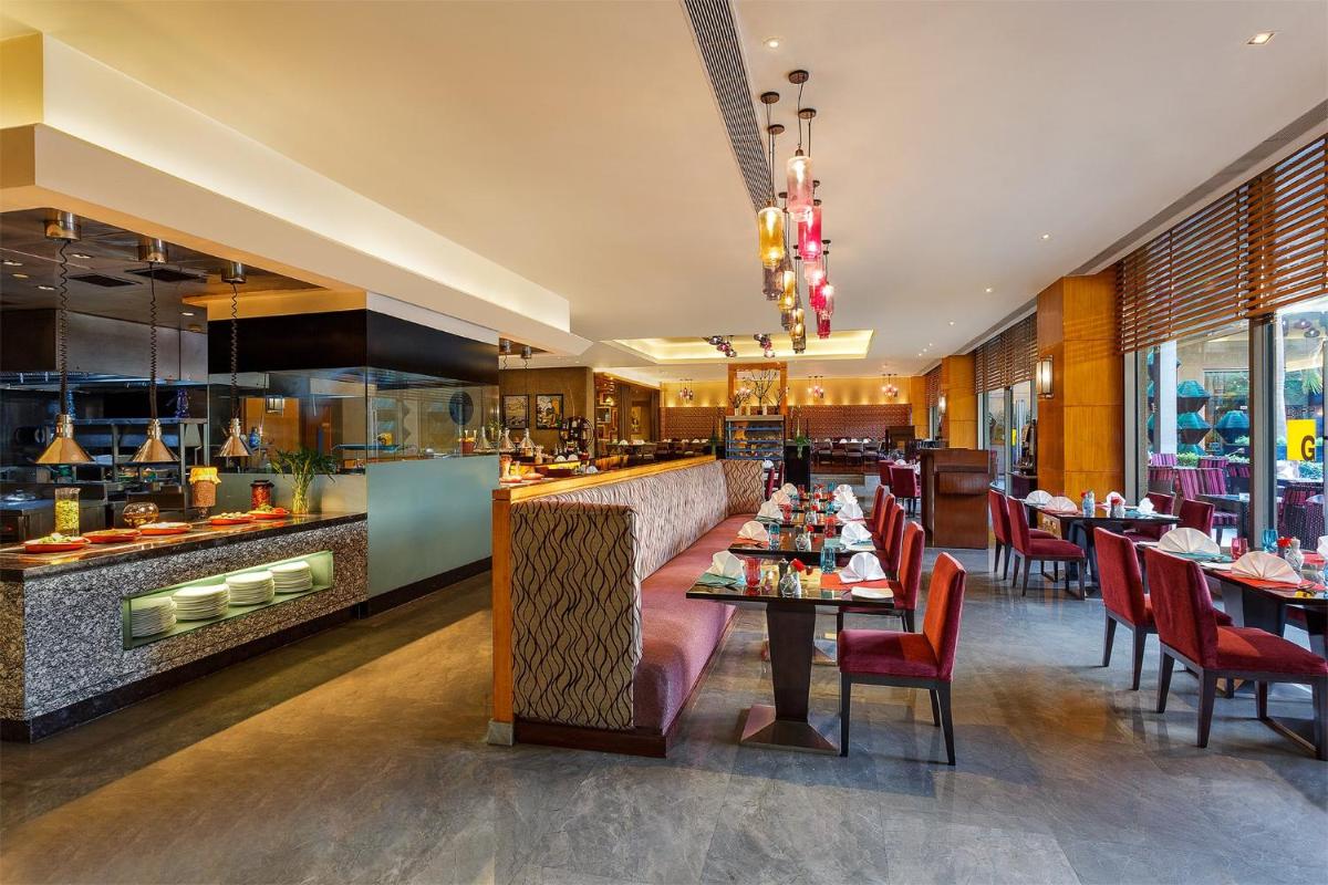 a restaurant with tables and chairs and a bar at Crowne Plaza Today Gurugram by IHG in Gurgaon