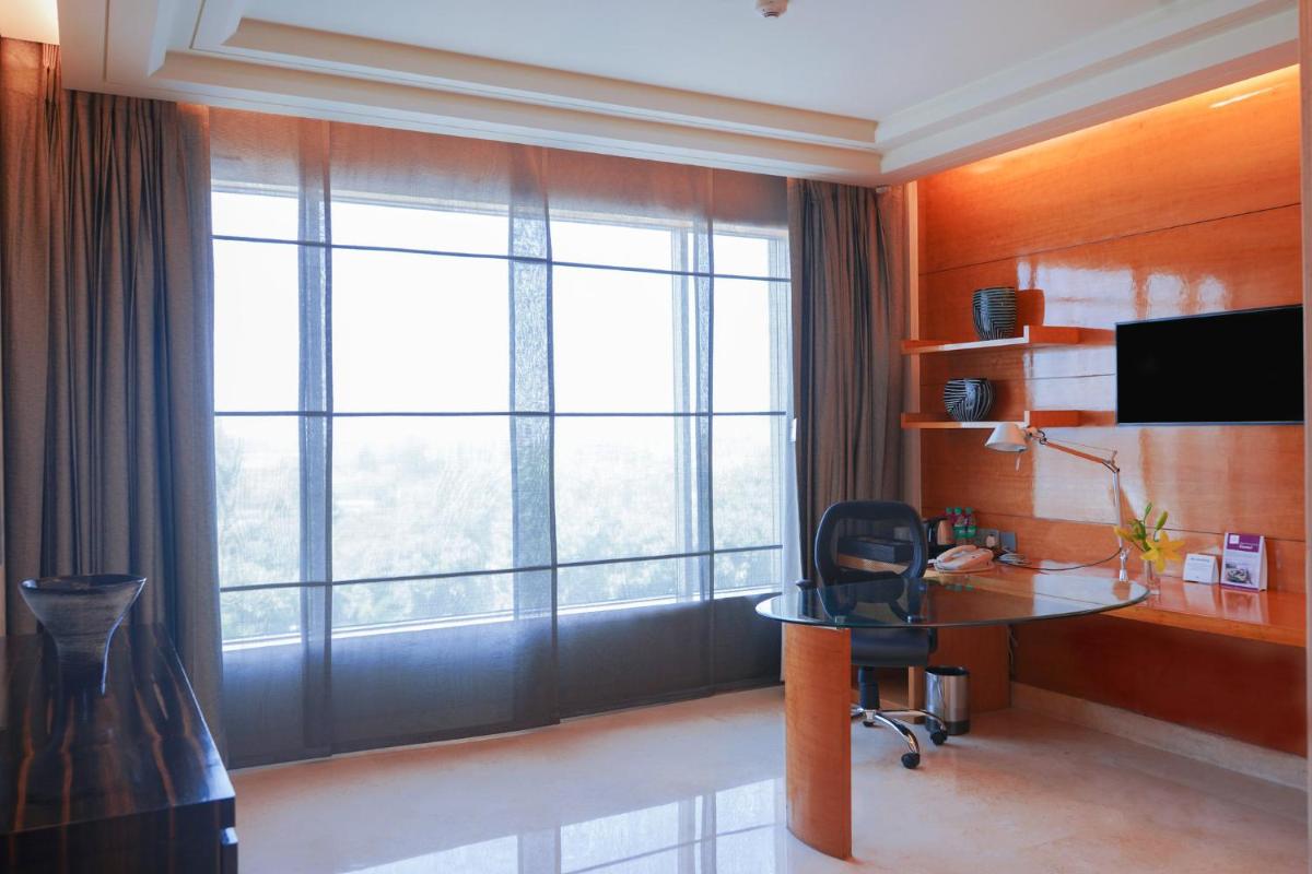 a room with a desk and a large window at Crowne Plaza Today Gurugram by IHG in Gurgaon