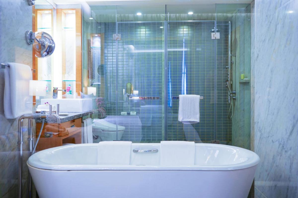 a bathroom with a tub and a shower and a sink at Crowne Plaza Today Gurugram by IHG in Gurgaon