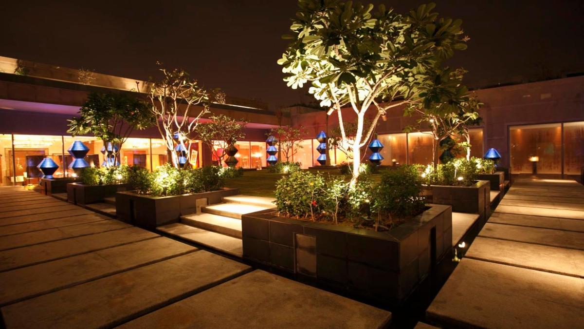 a group of potted trees in a courtyard at night at Crowne Plaza Today Gurugram by IHG in Gurgaon