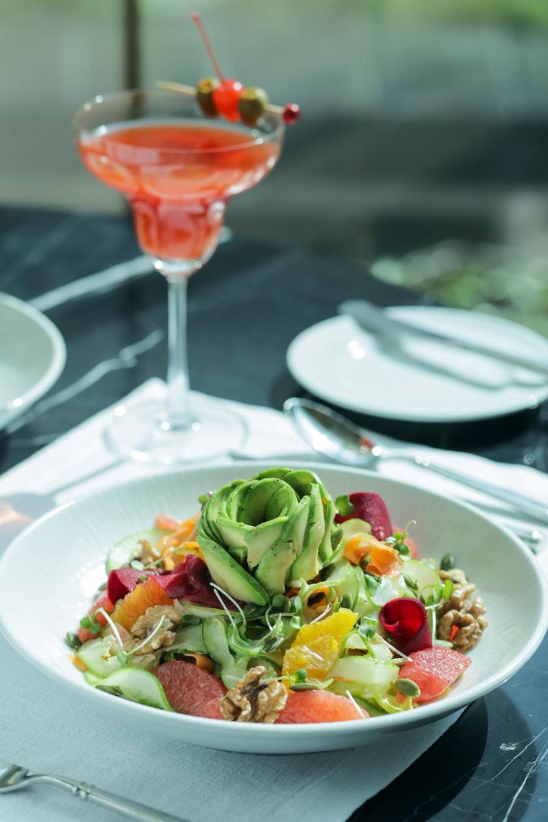 a salad in a white plate next to a drink at The Leela Palace New Delhi in New Delhi a salad in a white plate next to a drink at The Leela Palace New Delhi in New Delhi