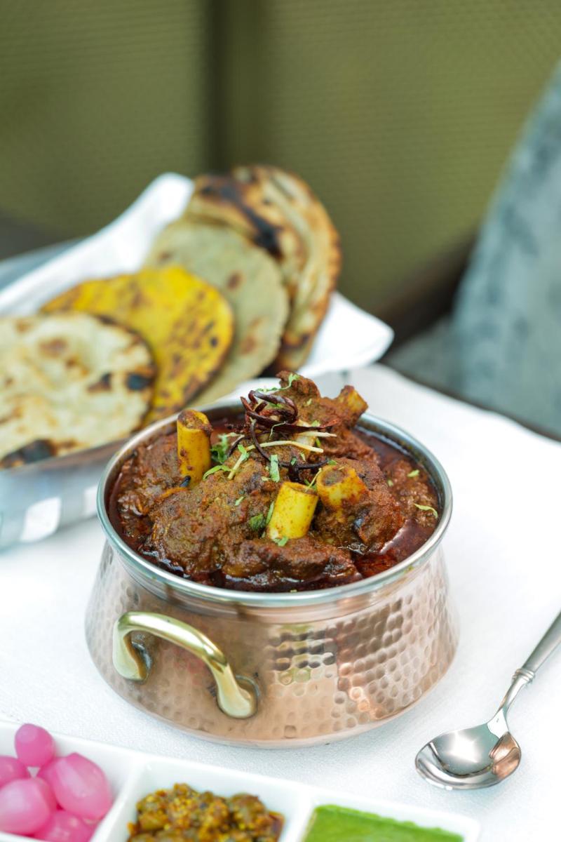 a bowl of food on a table with bread at The Leela Palace New Delhi in New Delhi a bowl of food on a table with bread at The Leela Palace New Delhi in New Delhi