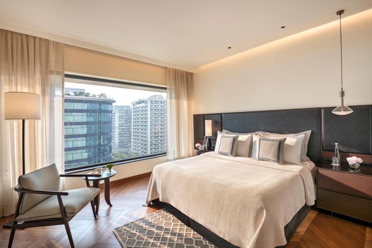 a bedroom with a large bed and a large window at The Oberoi Mumbai in Mumbai