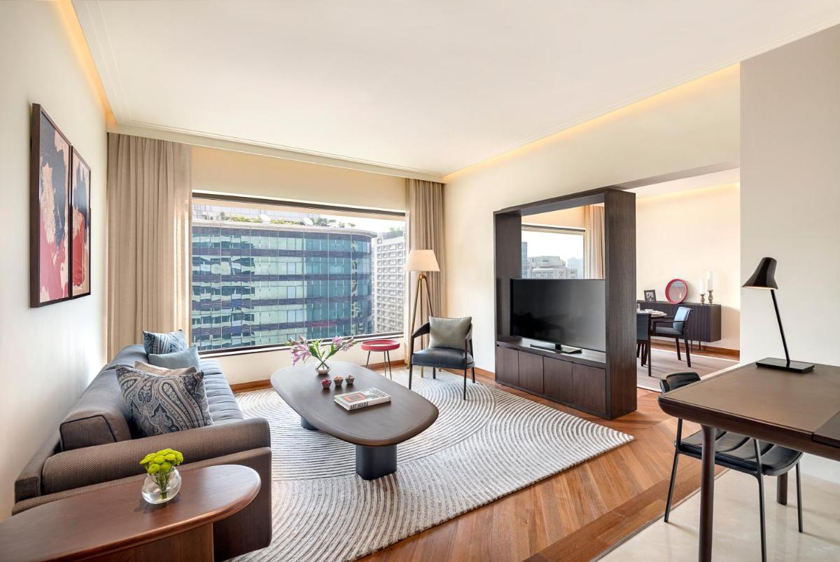 a living room with a couch and a tv at The Oberoi Mumbai in Mumbai