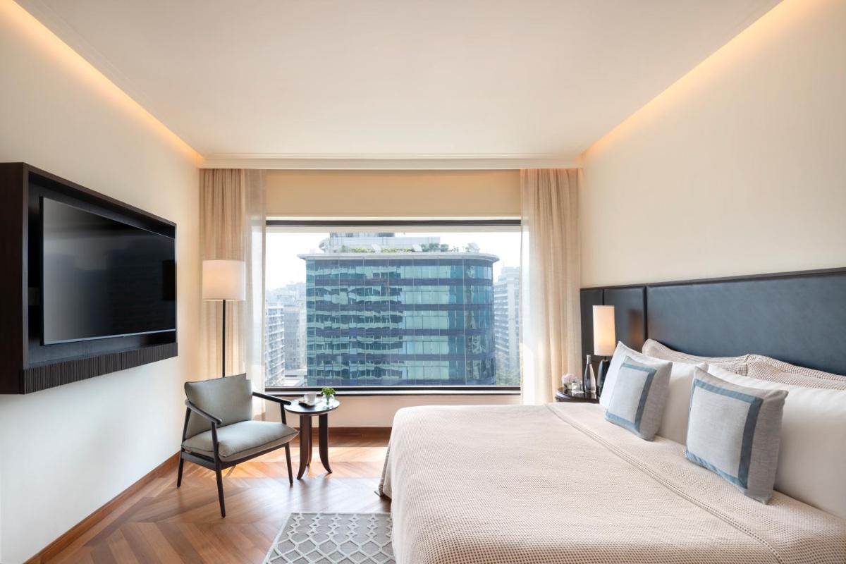 a hotel room with a large bed and a large window at The Oberoi Mumbai in Mumbai