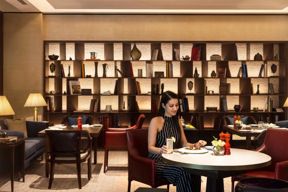 a woman sitting at a table in a restaurant at The Oberoi Mumbai in Mumbai