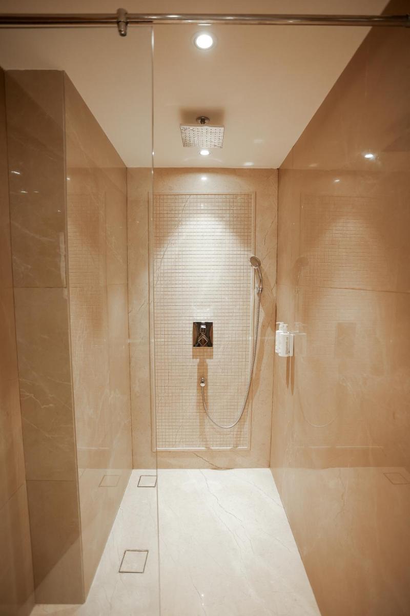a bathroom with a shower with a glass door at Golden Tulip Jaipur in Jaipur