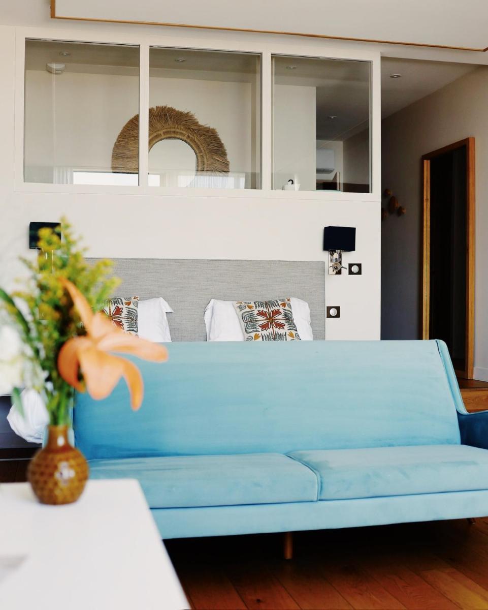 - un canapé bleu dans le salon dans l'établissement Résidence Les Suites du Port - by Le Saint Ferdinand, à Arcachon
