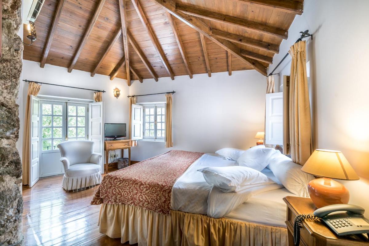 um quarto com uma cama grande e uma escrivaninha em Lawrences Hotel em Sintra