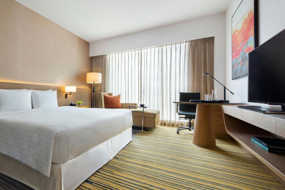 a hotel room with a bed and a desk at Courtyard by Marriott Bengaluru Outer Ring Road in Bengaluru