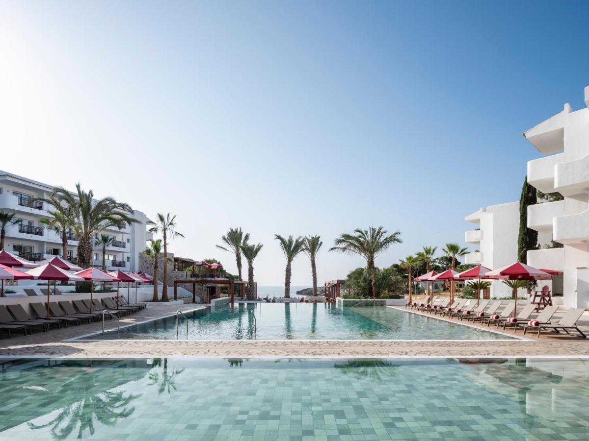 Una piscina con sillas y sombrillas en un resort. en Inturotel Esmeralda Park, en Cala d´Or
