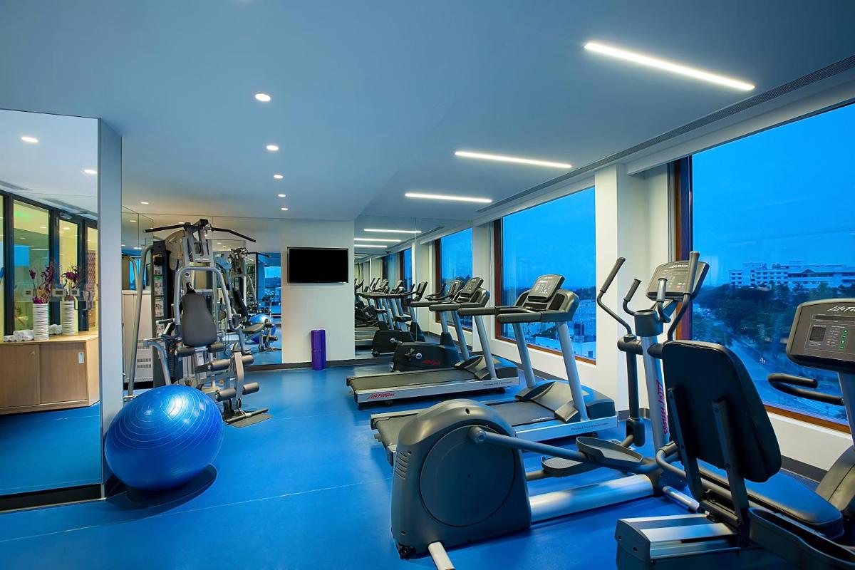 a gym with a lot of treadmills and machines at Grand Mercure Mysore - An Accor Brand in Mysore