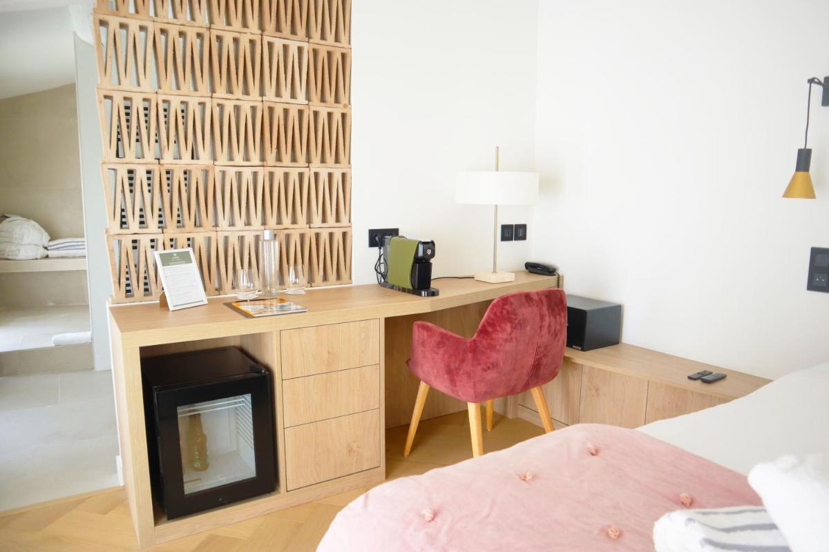 Cette chambre comprend un bureau avec une chaise et une cheminée. dans l'établissement Le Domaine Du Colombier, à Malataverne