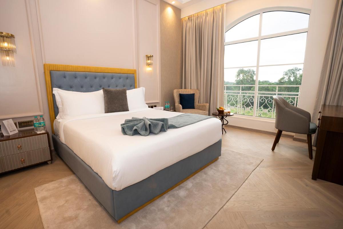 a bedroom with a large bed and a large window at Miros - Formerly Imperial Goa in Old Goa