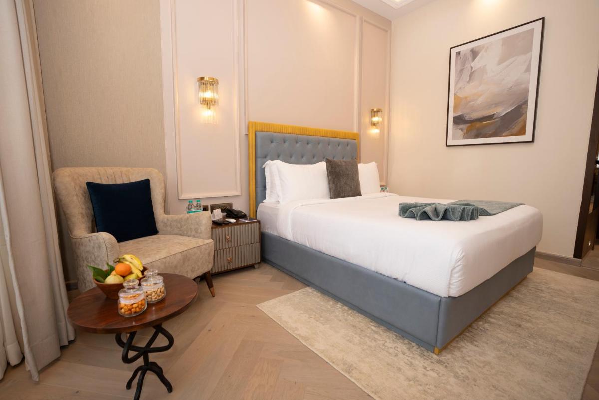 a hotel room with a bed and a chair at Miros - Formerly Imperial Goa in Old Goa