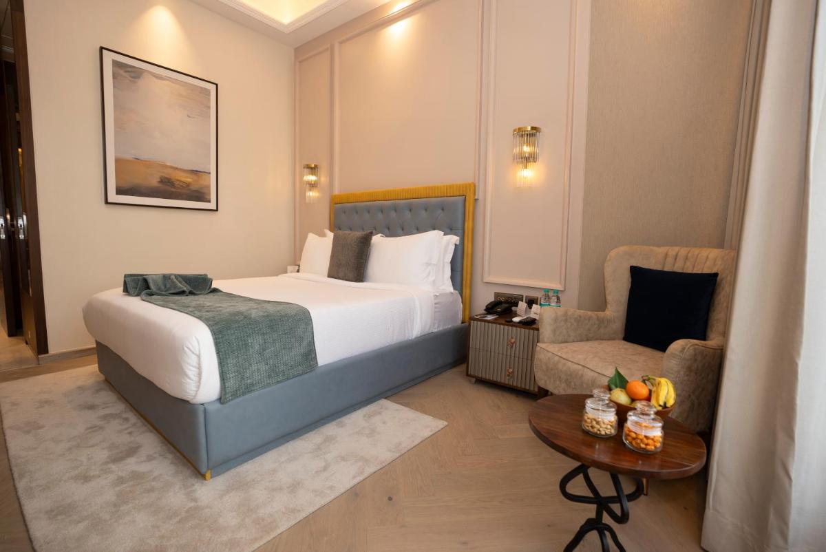 a hotel room with a bed and a chair at Miros - Formerly Imperial Goa in Old Goa
