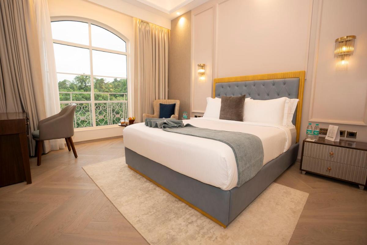 a bedroom with a large bed and a large window at Miros - Formerly Imperial Goa in Old Goa +49 photos