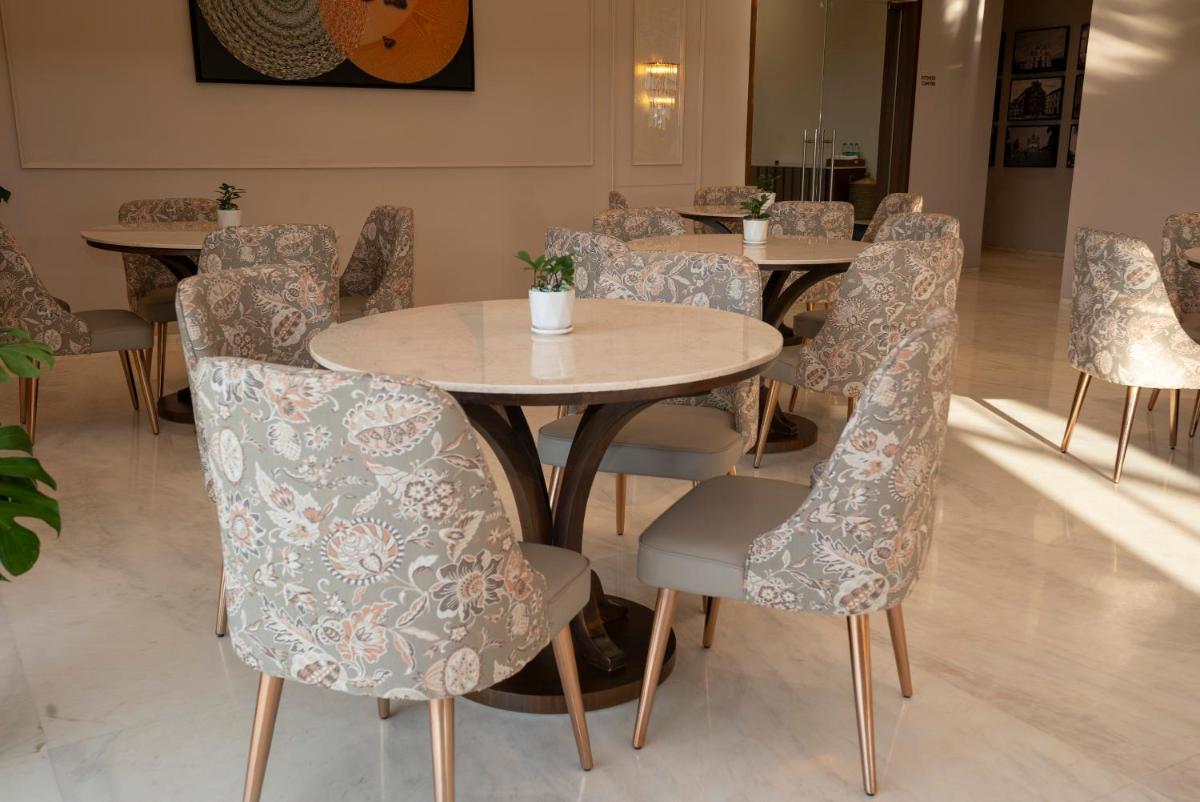a group of tables and chairs in a room at Miros - Formerly Imperial Goa in Old Goa
