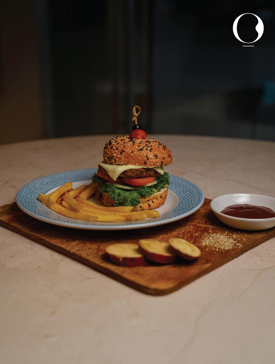 a hamburger and french fries on a plate on a table at Miros - Formerly Imperial Goa in Old Goa