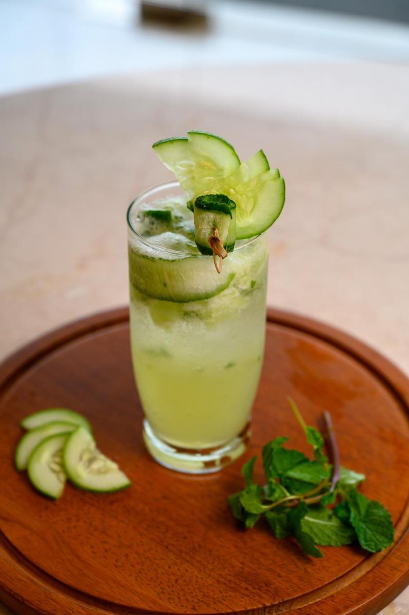 a drink on a wooden plate with an avocado on top at Miros - Formerly Imperial Goa in Old Goa
