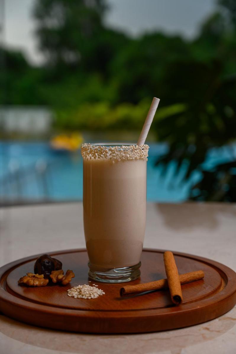 a drink on a wooden tray with cinnamon sticks and aucer at Miros - Formerly Imperial Goa in Old Goa