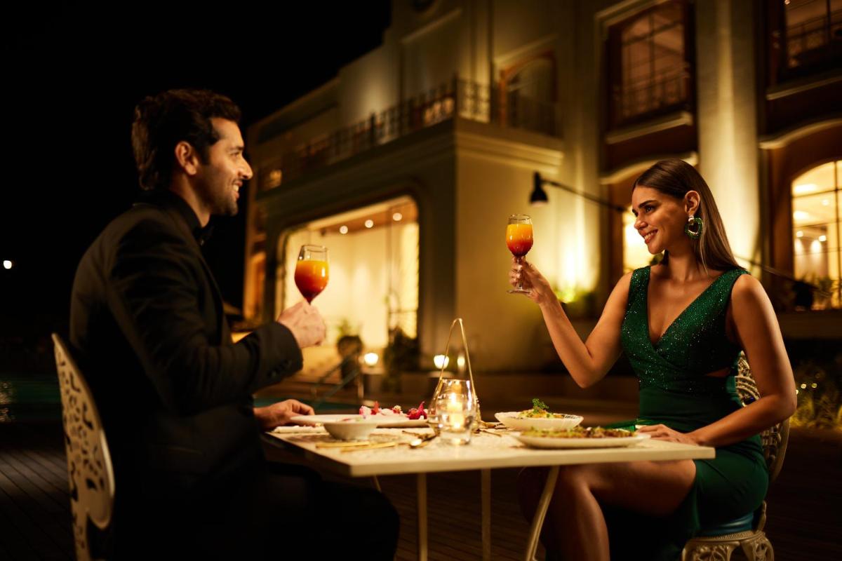a man and woman sitting at a table drinking wine at Miros - Formerly Imperial Goa in Old Goa