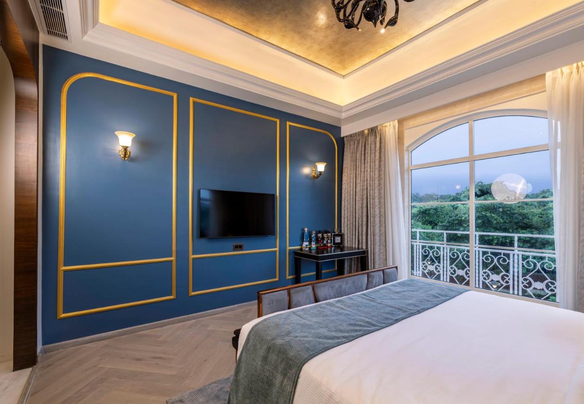 a bedroom with a bed and a large window at Miros - Formerly Imperial Goa in Old Goa