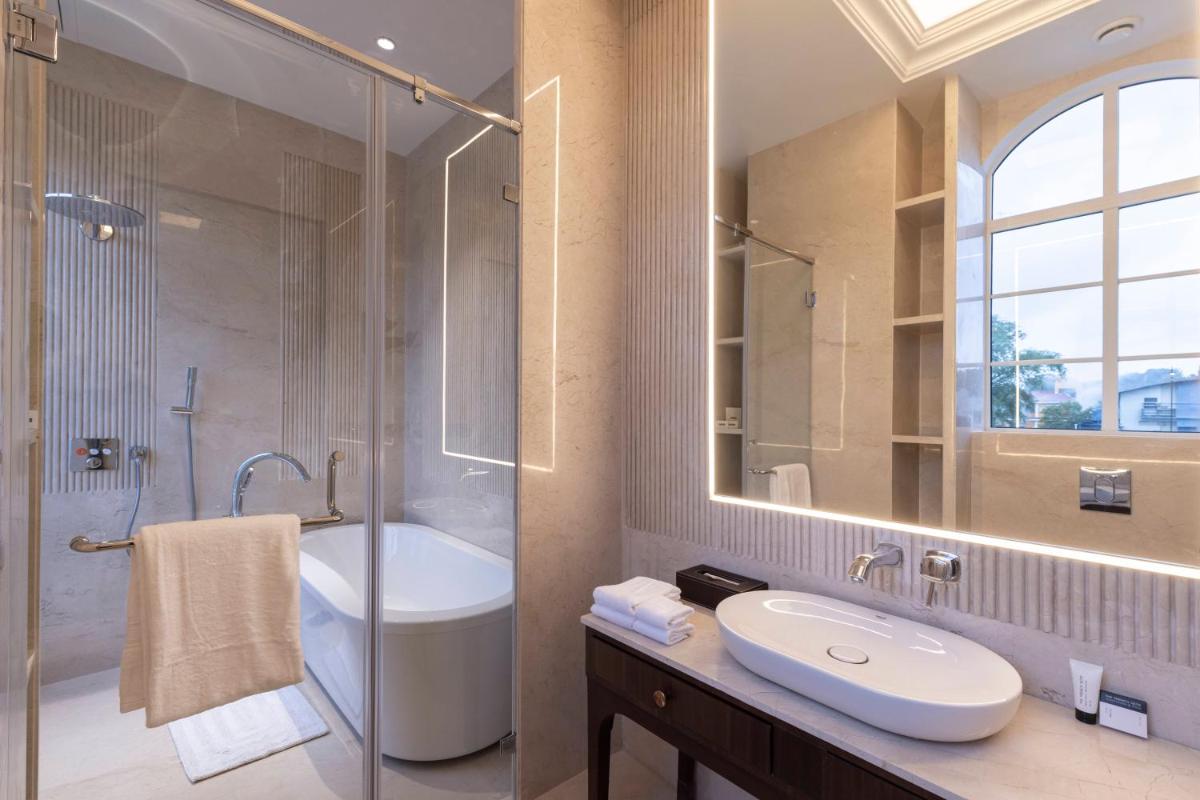 a bathroom with a shower and a sink and a tub at Miros - Formerly Imperial Goa in Old Goa