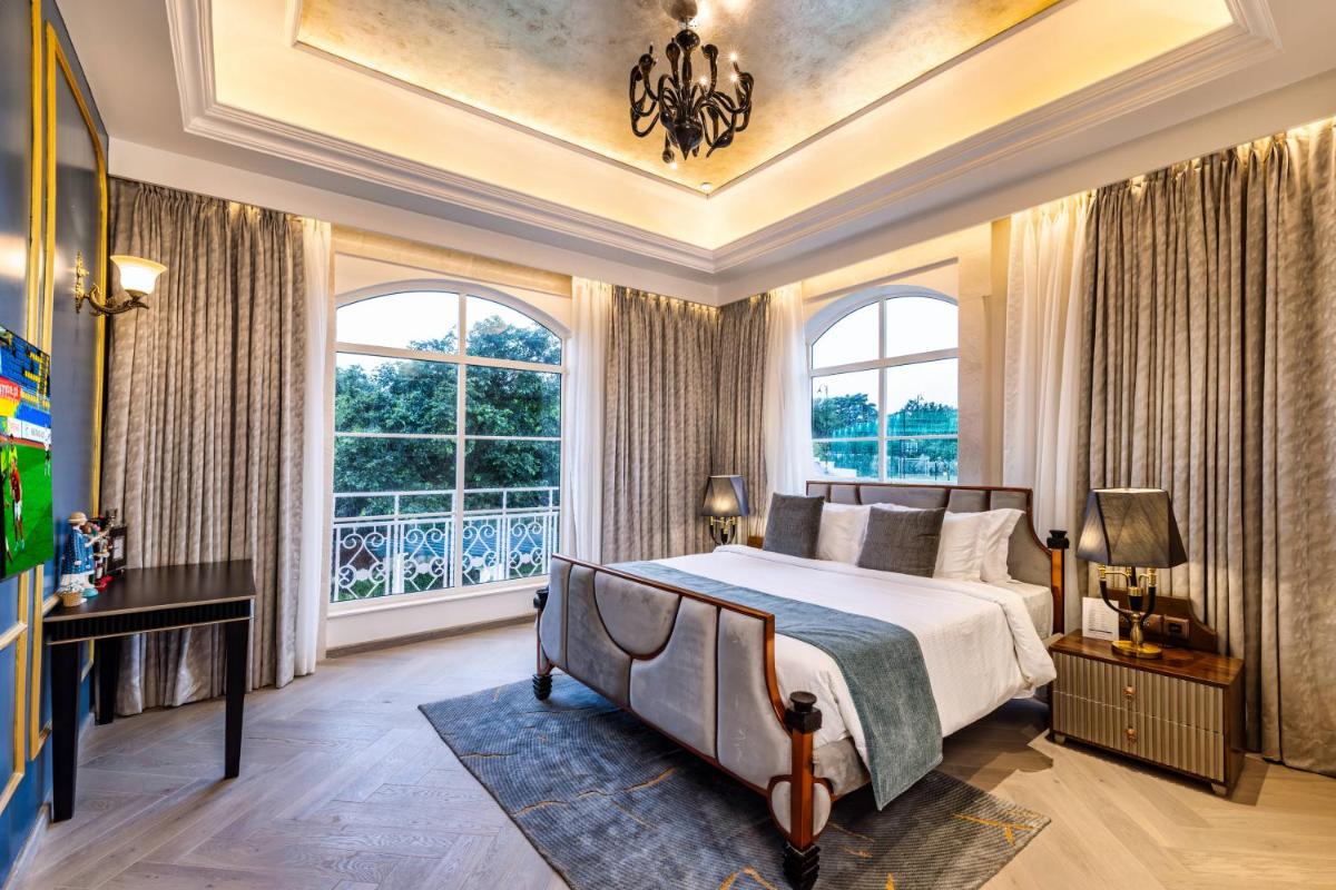 a bedroom with a bed and a large window at Miros - Formerly Imperial Goa in Old Goa