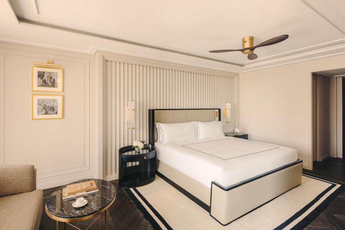 a bedroom with a white bed and a couch at Fairmont Mumbai in Mumbai