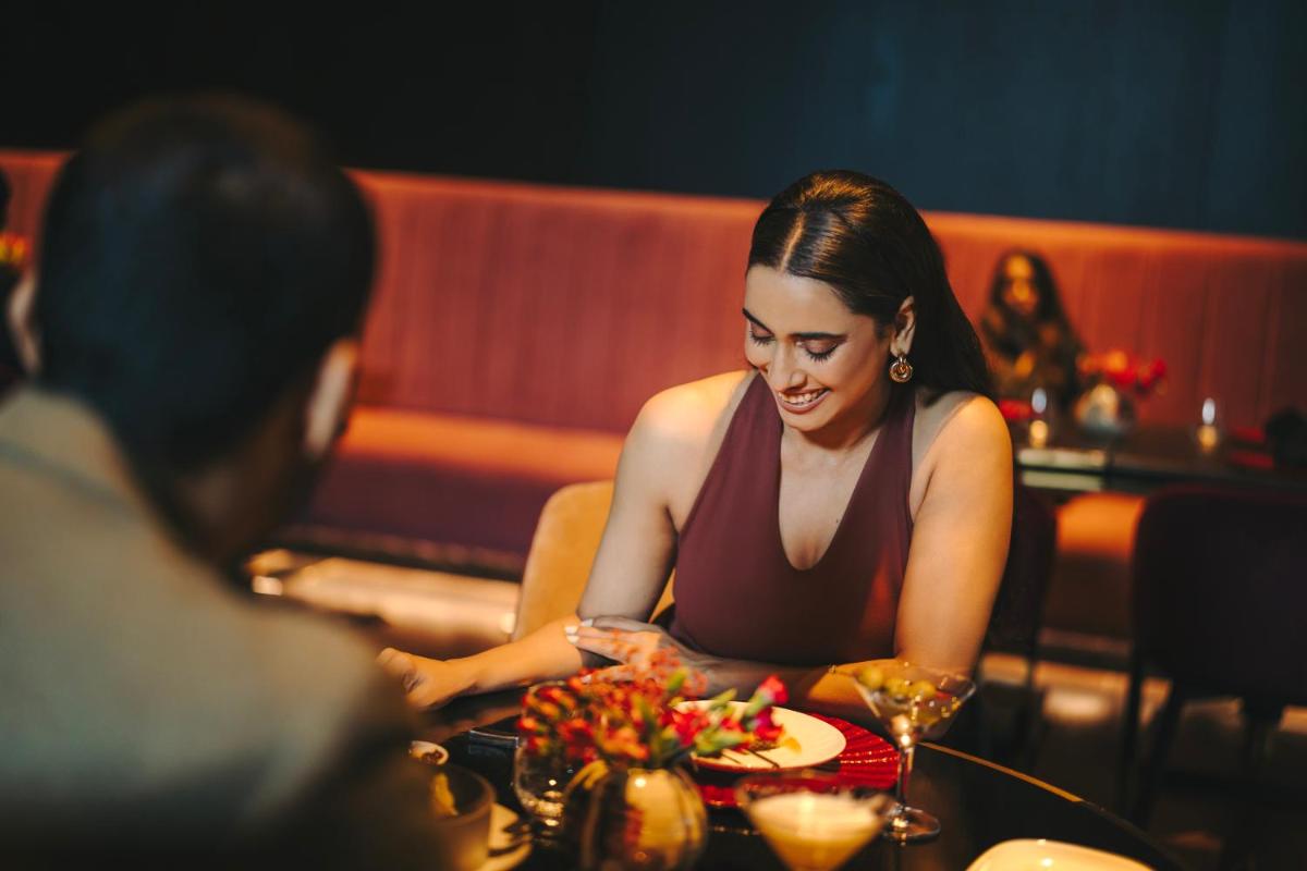 a woman sitting at a table with a plate of food at Fairmont Mumbai in Mumbai