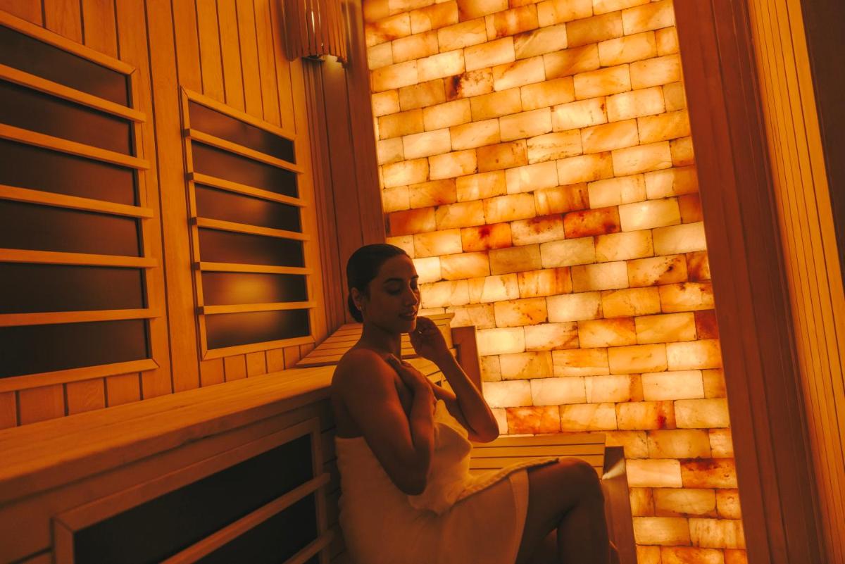 a woman sitting on a bench in front of a brick wall at Fairmont Mumbai in Mumbai