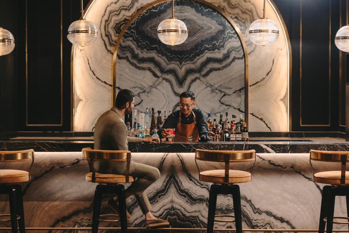 a man sitting at a bar in front of a mirror at Fairmont Mumbai in Mumbai