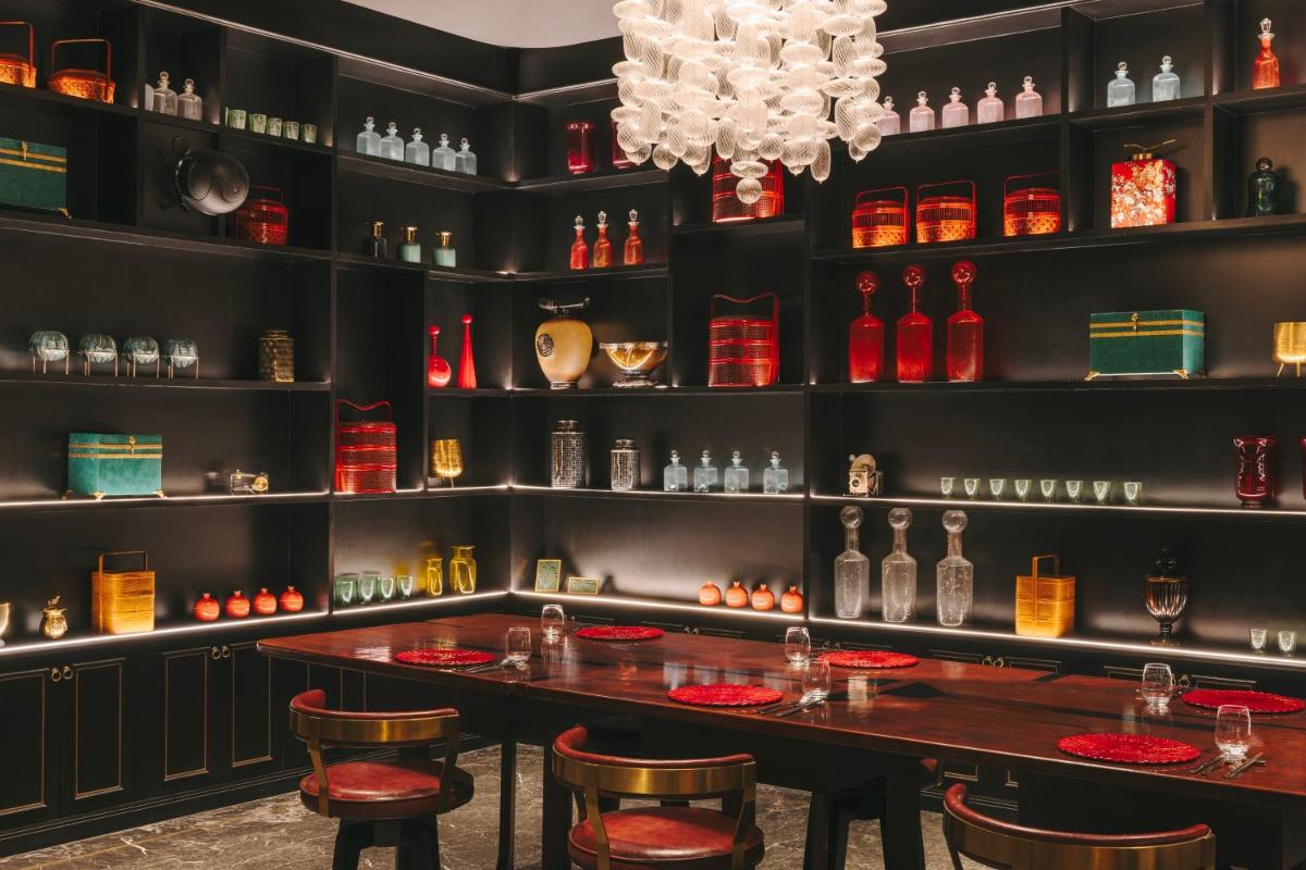 a dining room with a table and shelves of wine bottles at Fairmont Mumbai in Mumbai