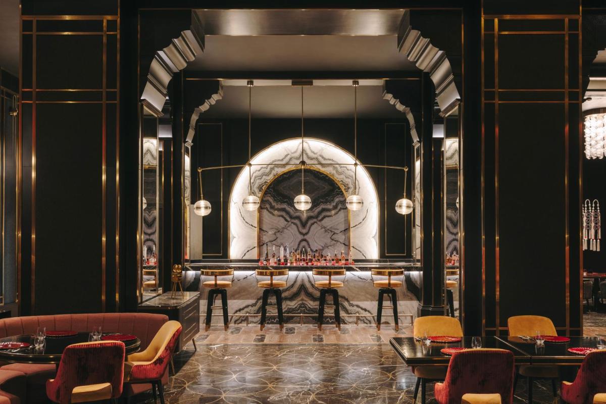 a dining room with a table and chairs at Fairmont Mumbai in Mumbai