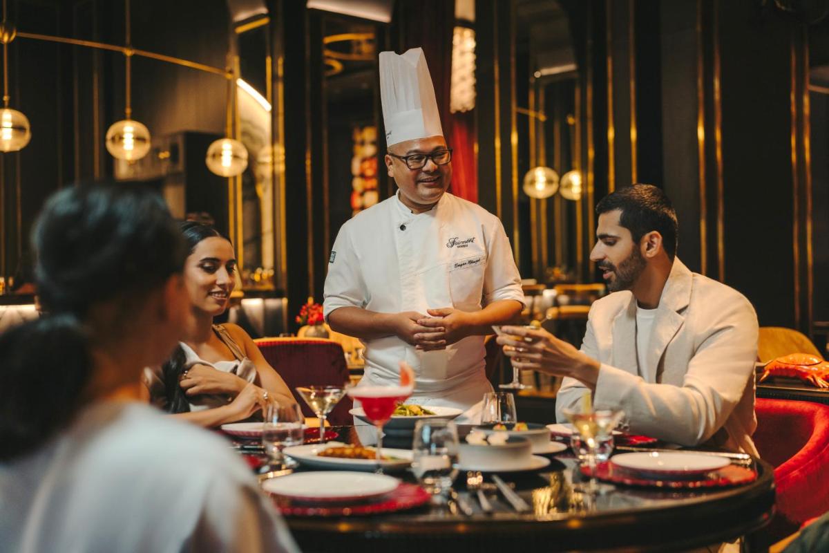 a group of people sitting around a table in a restaurant at Fairmont Mumbai in Mumbai