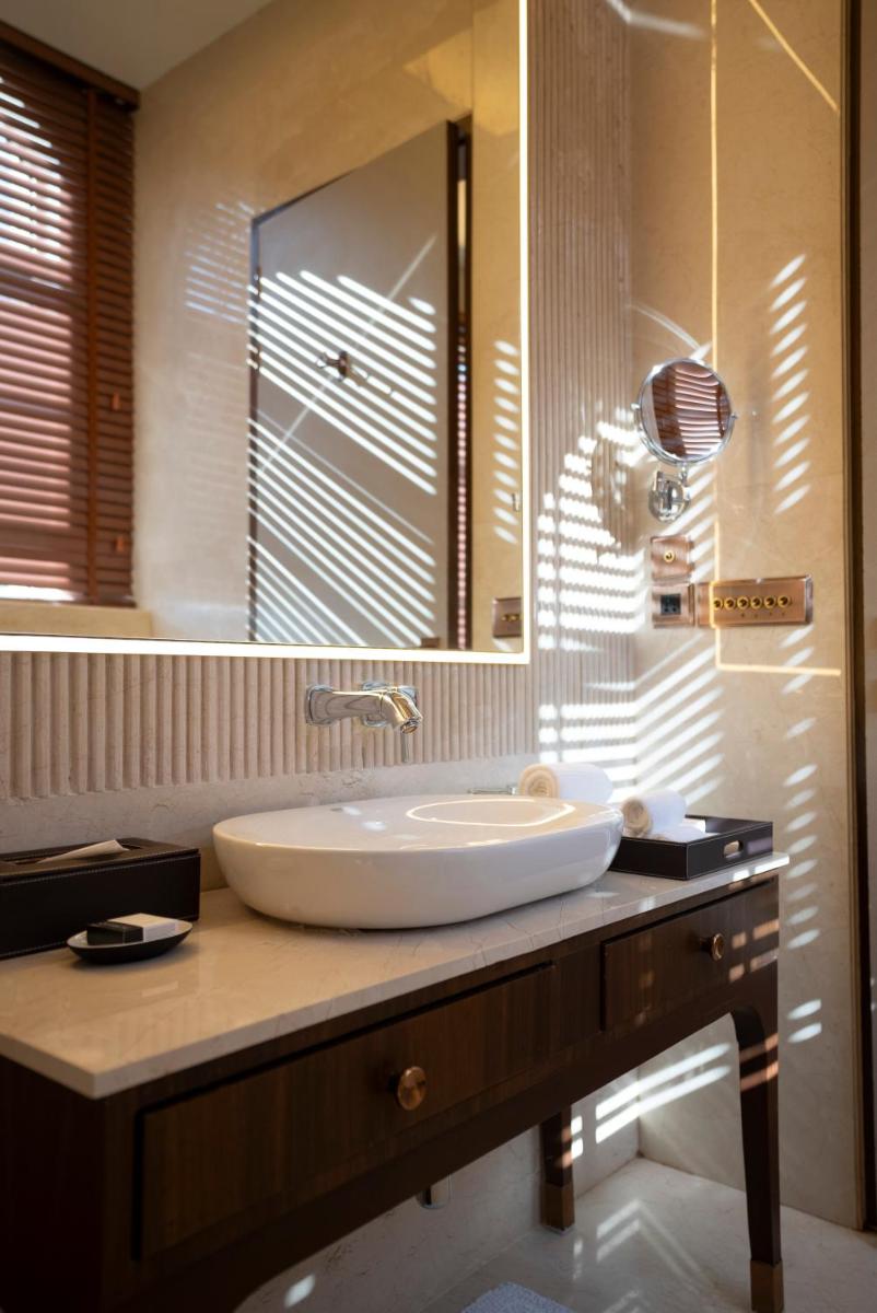 a bathroom with a sink and a large mirror at Miros - Formerly Imperial Goa in Old Goa