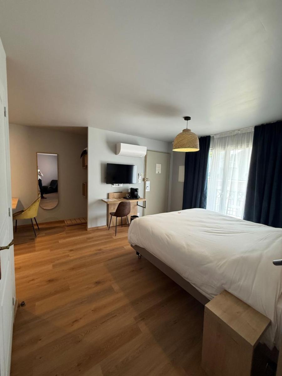 une chambre avec un grand lit et un bureau dans l'établissement Tulip Inn Honfleur Residence & Spa, à Honfleur
